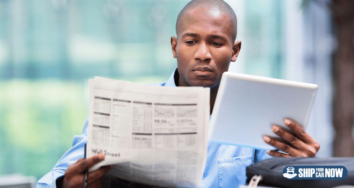 A person looking at papers to compare car shipping quotes