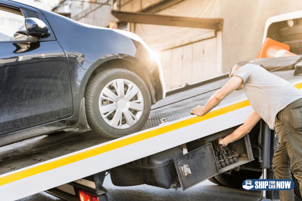 Man loading a car onto a tow truck